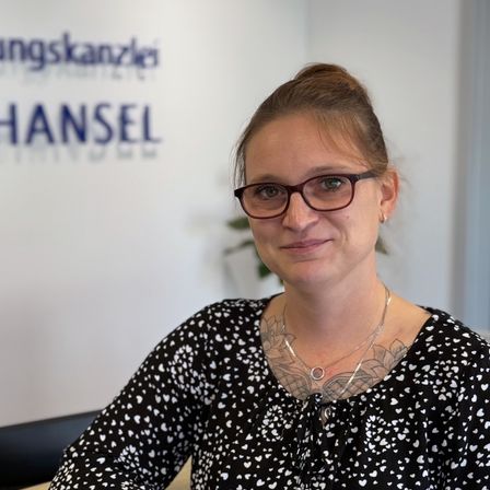 Darline, die Steuerfachgestellte steht an der Empfangstehke in der Steuerkanzlei